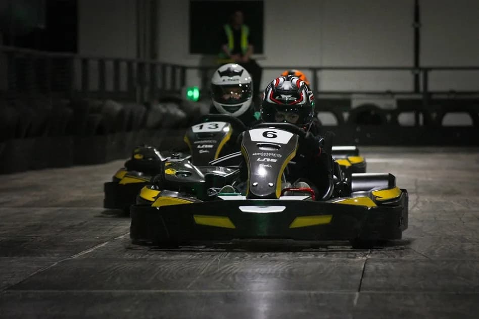 Two go-karts on the indoor double-level track at Absolutely Karting Bristol