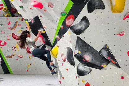 Climber scaling a bouldering wall at 270 Climbing Park in Gloucester