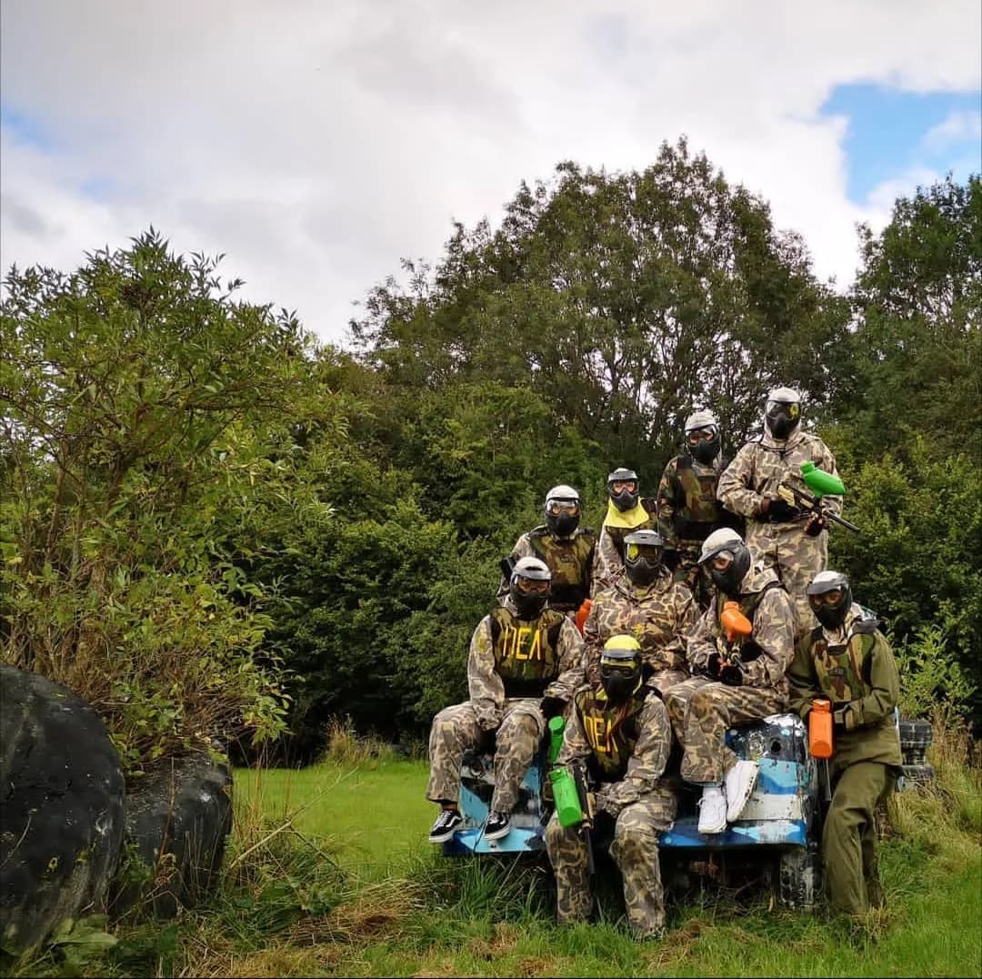 Paintball players in protective gear on the outdoor field at Swindon Paintball