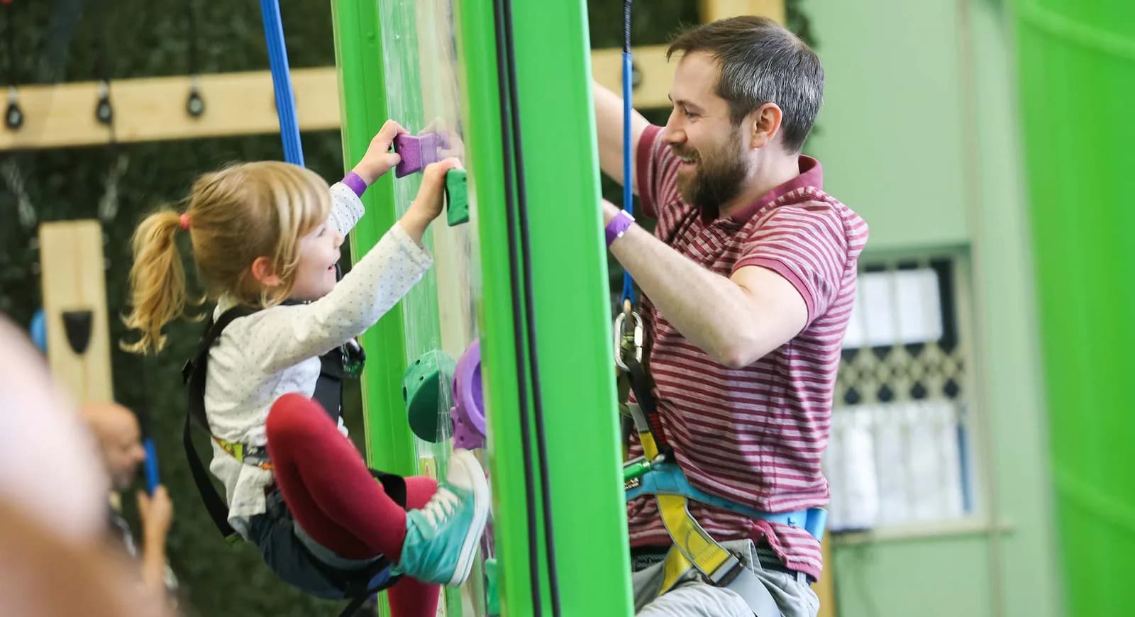 Child and adult climbing the green Clip 'n Climb walls at Clip 'n Climb Nottingham