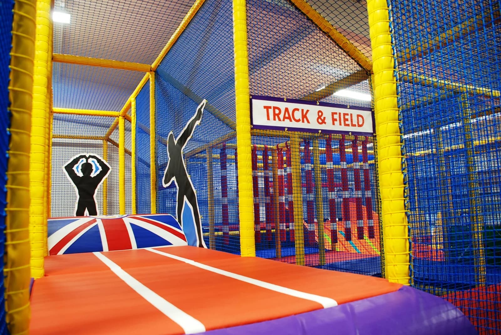 Multi-level indoor soft play frame with track and field themed zone at 360 Play Leicester