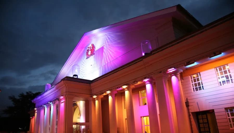 De Montfort Hall exterior at night with multi-coloured illuminations