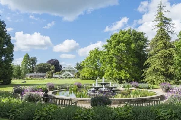 The fountain pond with glasshouse range behind at Cambridge University Botanic Garden