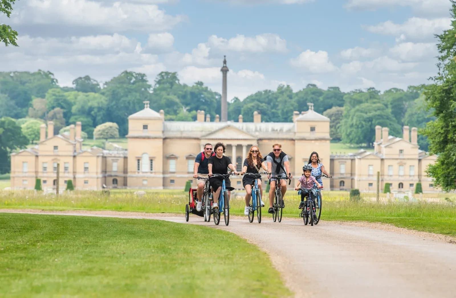 Families cycling in front of Holkham Hall