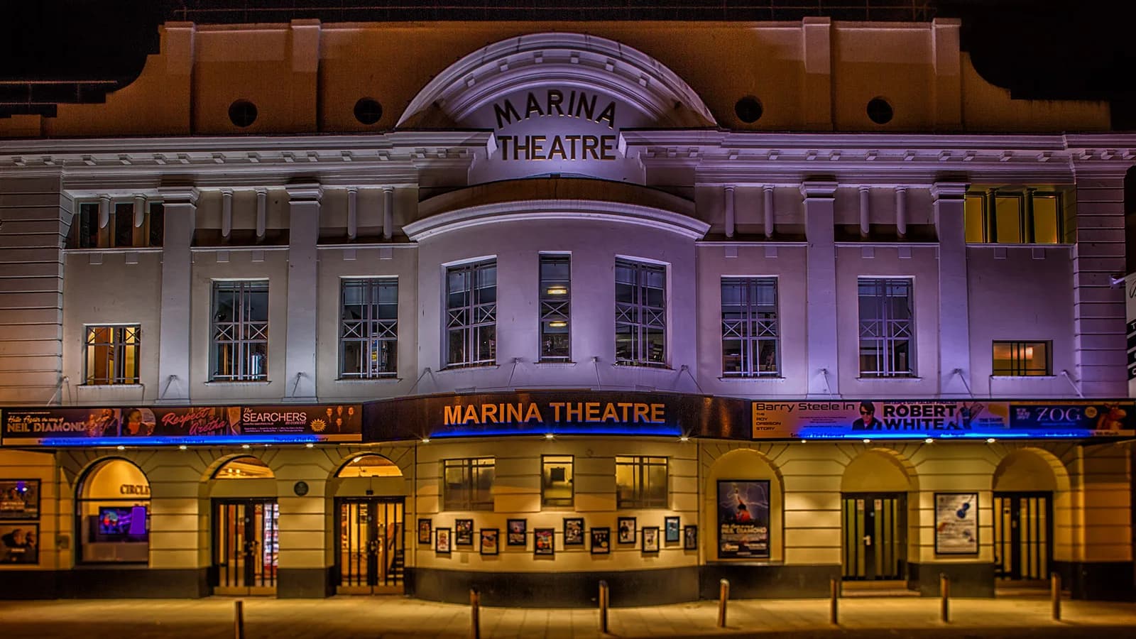 Exterior of Marina Theatre, Lowestoft at night showing the illuminated facade and entrance