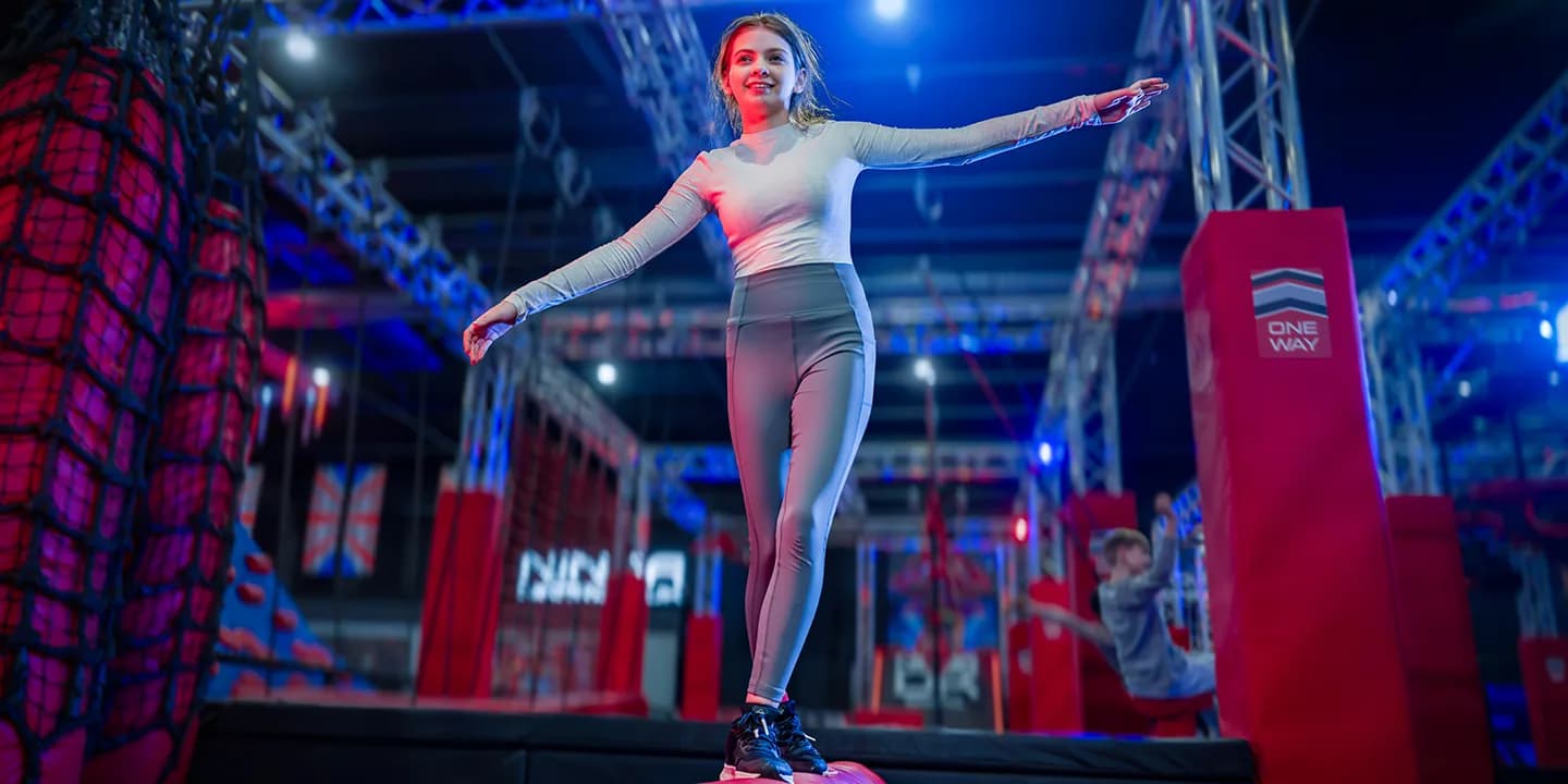Child tackling a red padded traverse obstacle on the Ninja Warrior UK Watford ninja course