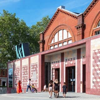 Young V&A exterior entrance with modern geometric patterned cladding and historic Victorian brick building