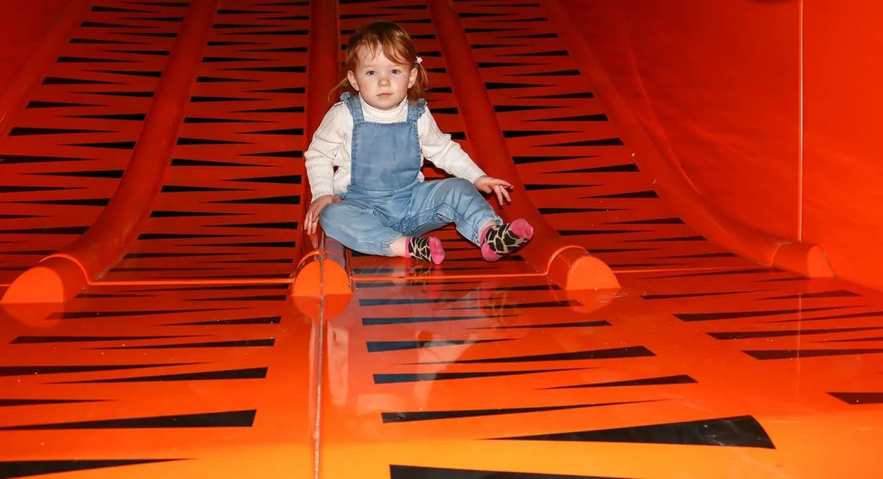 Toddler on the tiger-striped slide at Blackpool Zoo Playbarn indoor soft play