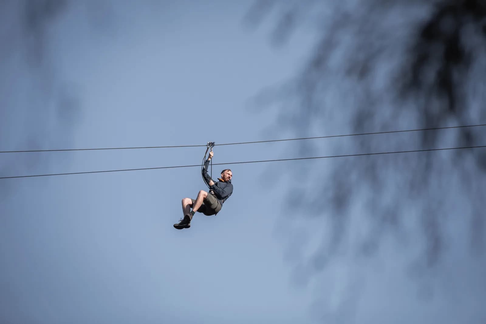 Person on a zip wire soaring over forest at Go Ape Aberfoyle