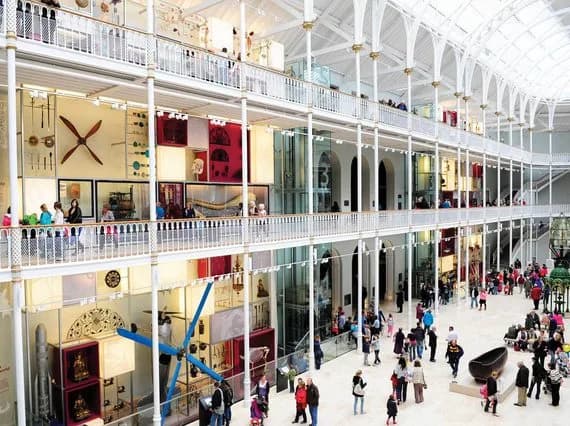The Grand Gallery at the National Museum of Scotland - a multi-level open museum space with balconies and an arched ceiling filled with visitors exploring exhibits