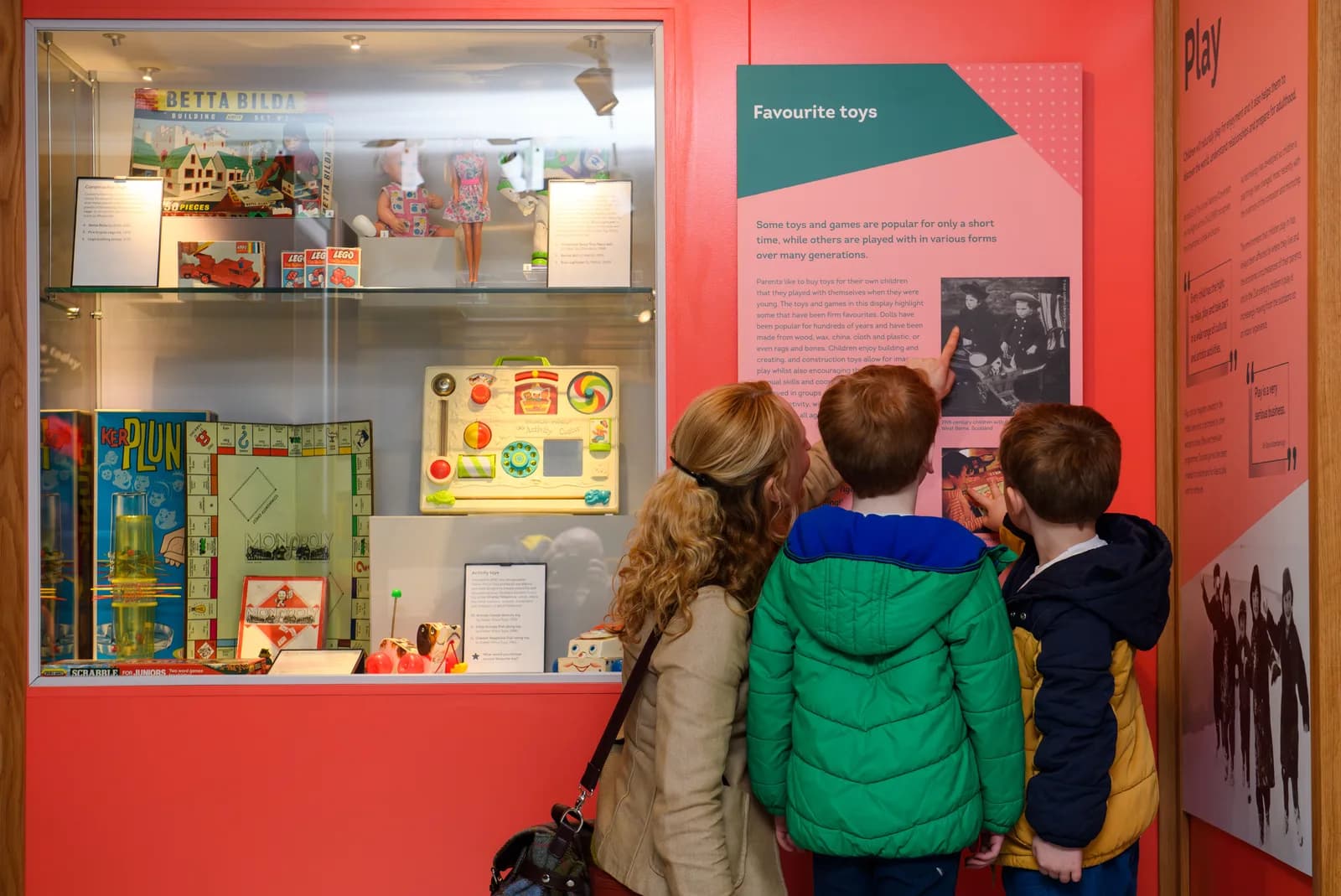 Children gathered around a vibrant toy display case at the Museum of Childhood Edinburgh