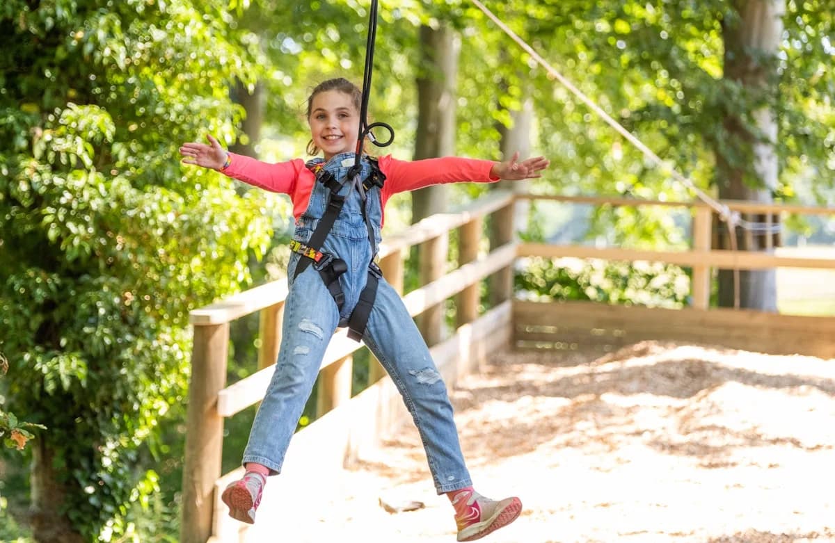 Young adventurer flying down a zip line at Go Ape Dalkeith Edinburgh, Dalkeith Country Park