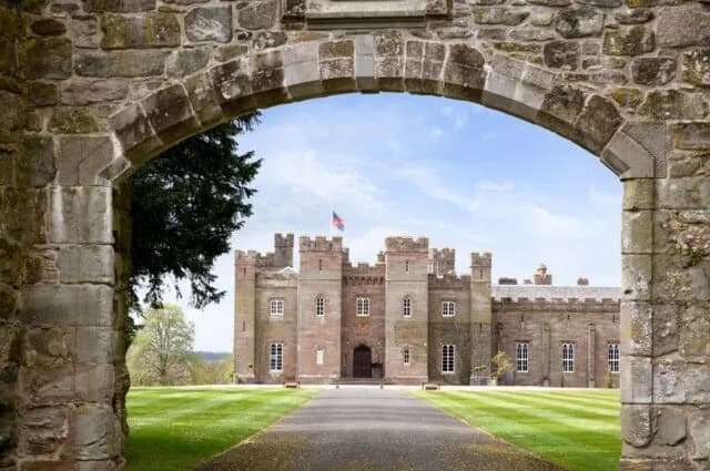 Scone Palace viewed through an ancient stone archway on the estate grounds