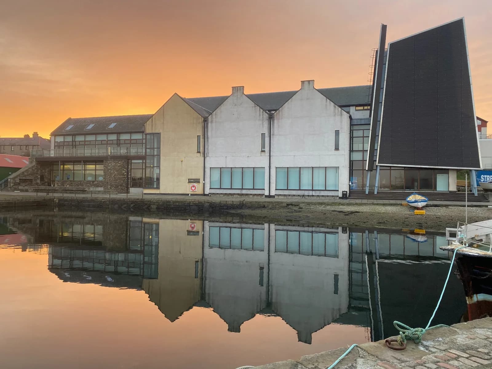 Shetland Museum & Archives exterior at sunset with waterfront reflection