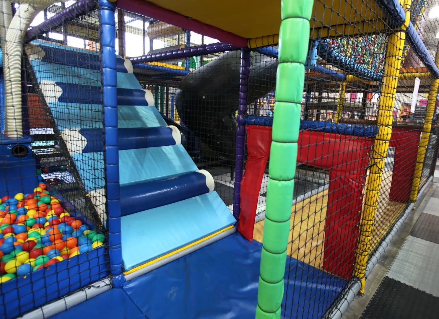 Indoor soft play area with ball pit and tube slide at Soft Landings Play Zone, Bridgend