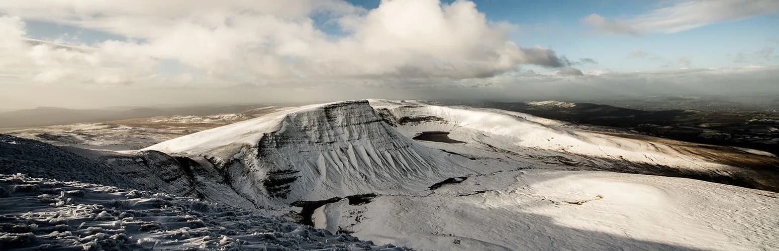 Snow-covered mountains and glacial lake in the Brecon Beacons National Park winter landscape