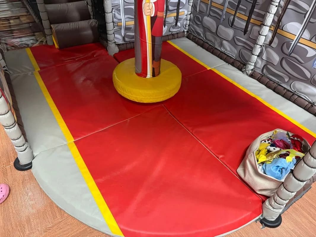 Multi-level indoor soft play structure with padded walkways and safety netting at Mini Kingdom Soft Play