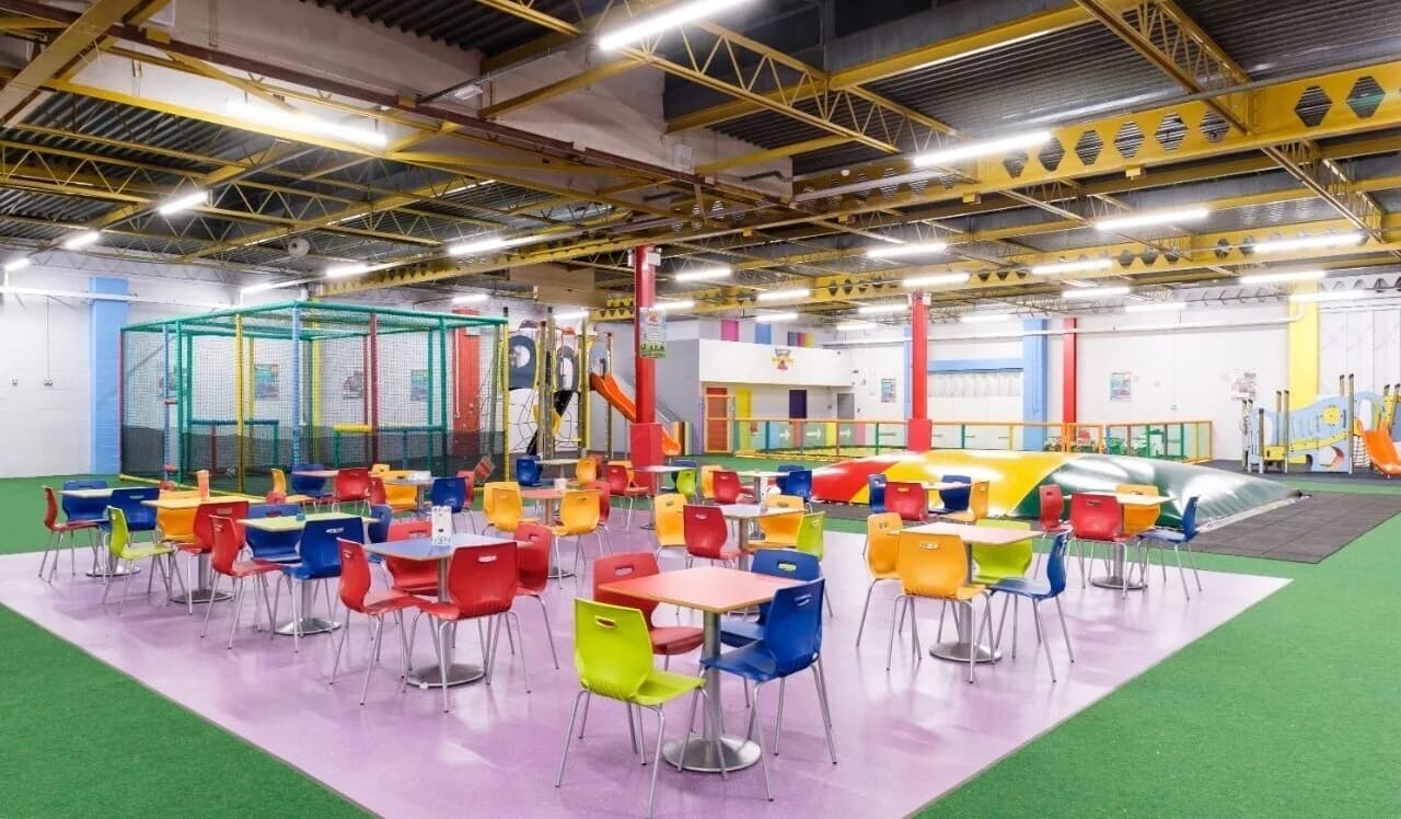Main play area at Berzerk Active Play Birmingham showing soft play equipment, cafe seating, and Berzerk branding