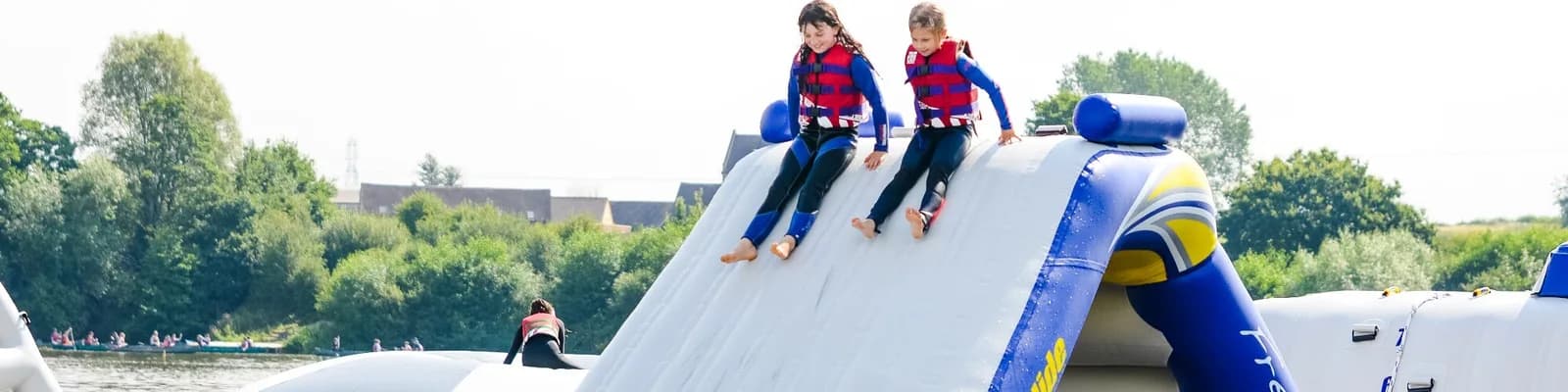 Children on the Aztec Adventure Aqua Park inflatable slide at Upton Warren