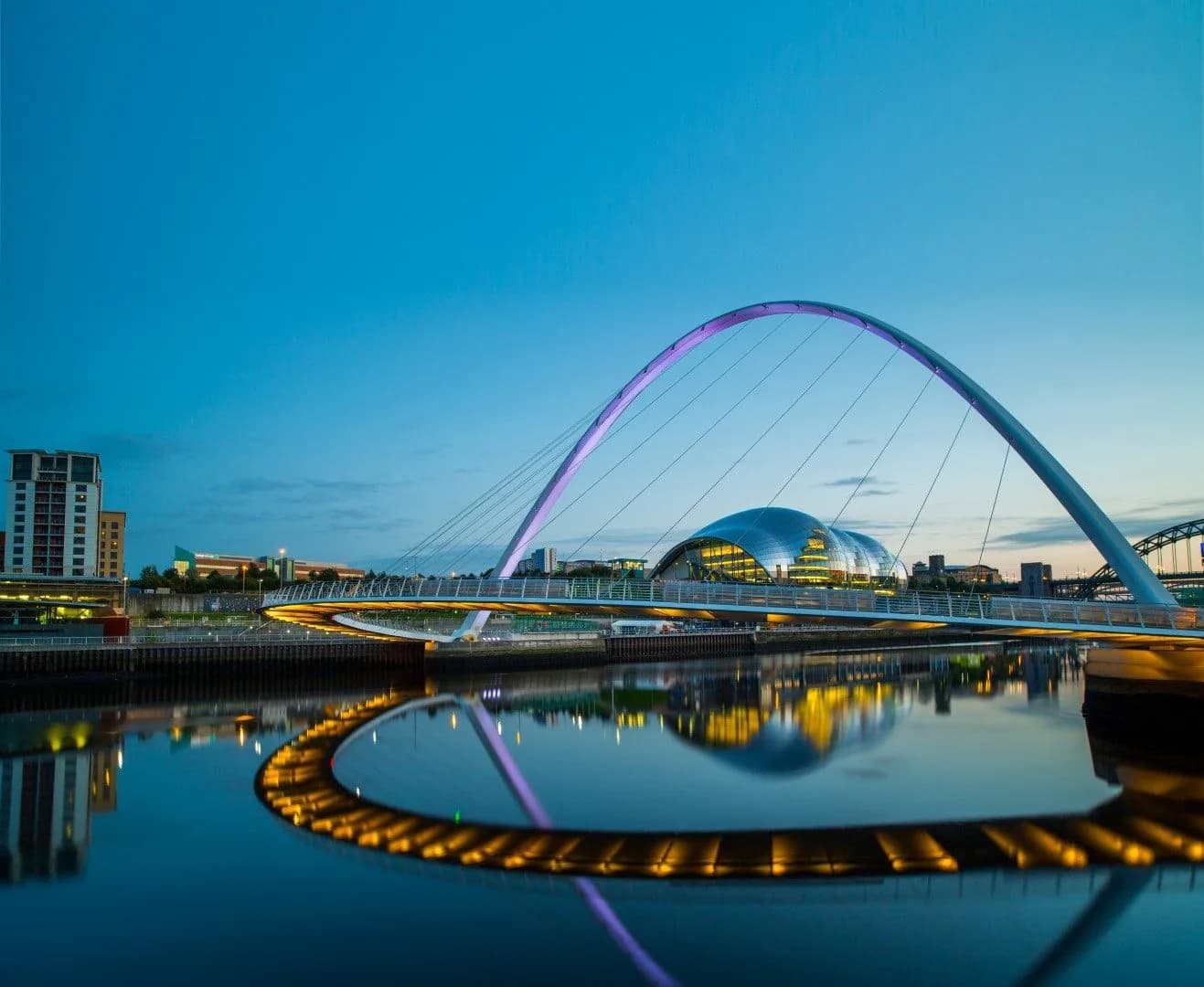 The Glasshouse exterior at sunset with Gateshead Millennium Bridge