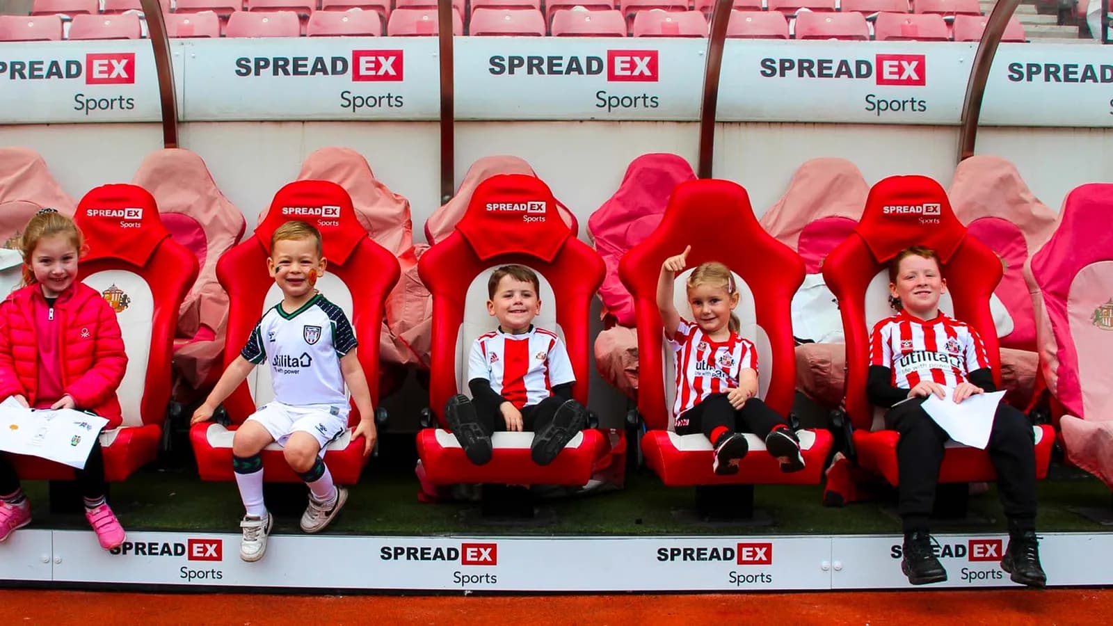 Children in football kit at Foundation of Light dugout