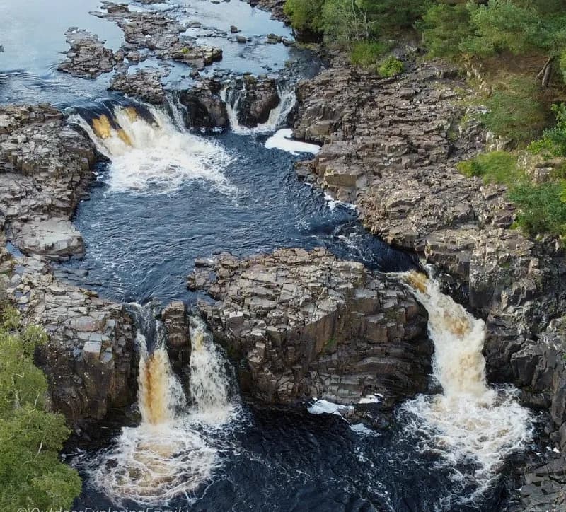 Aerial view of Low Force waterfall showing stepped cascades over Whin Sill rock in Teesdale