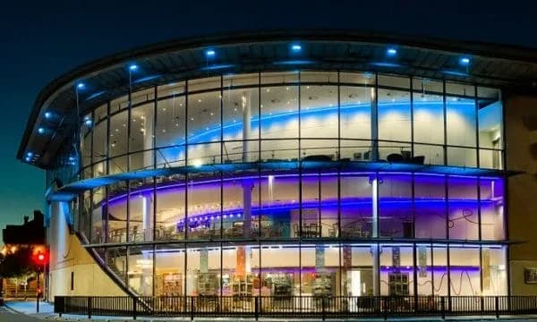 Exterior of ARC Stockton Arts Centre at night, a modern glass-fronted building on the corner of Dovecot Street