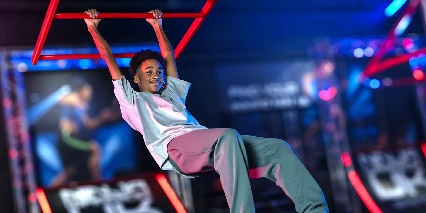 Child hanging and climbing on a ninja warrior obstacle course at Ninja Warrior UK Teesside