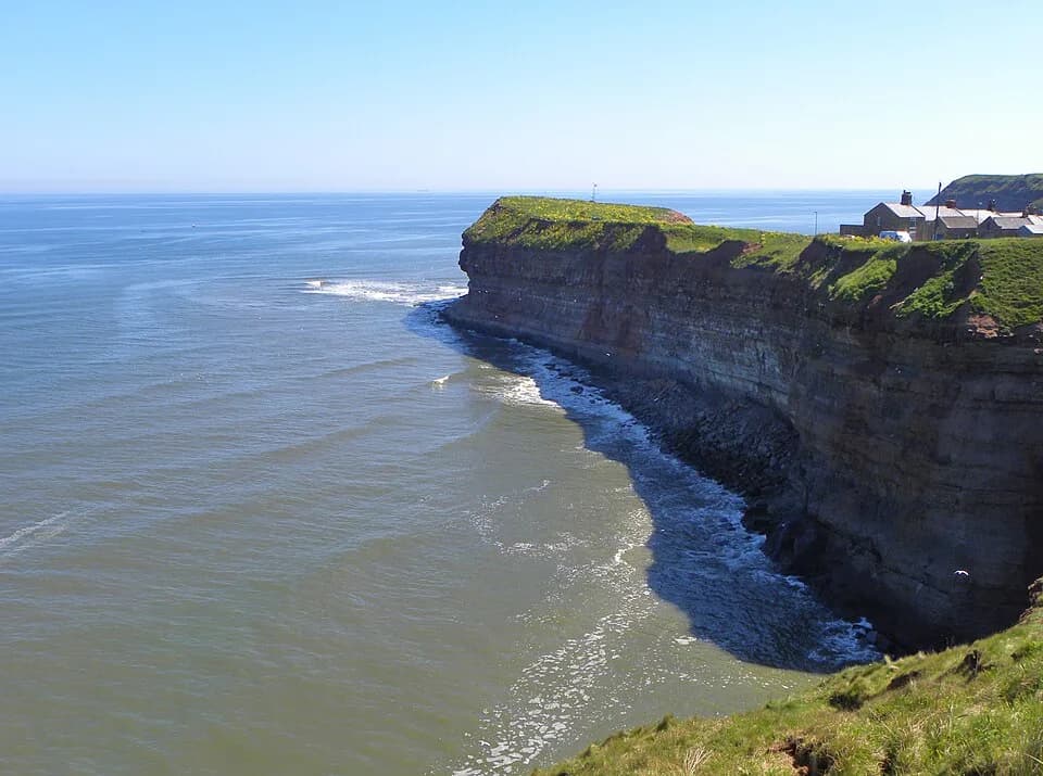 Layered sedimentary cliffs at Cowbar near Staithes, with the sea below