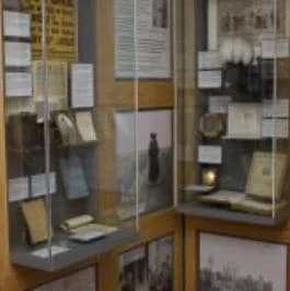 Museum interior with display cabinets showcasing John Buchan memorabilia, books, and historical artefacts at The John Buchan Story, Peebles