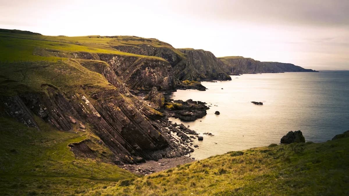 The coastline at St Abb's Head, where steep rocky cliffs plunge towards the sea with grass-covered clifftops