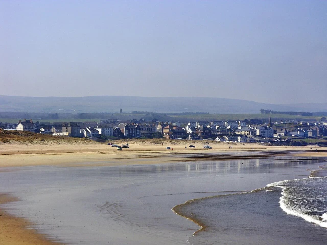 View of Castlerock village from Castlerock Beach in 2010, showing the sandy beach and distant cliffs
