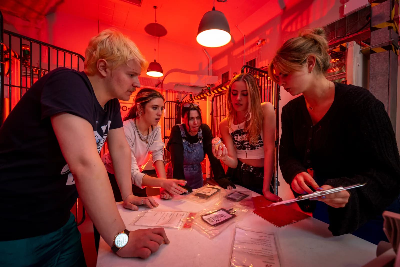 Team of players solving clues in a red-lit escape room at Locked In Edinburgh, Summerhall