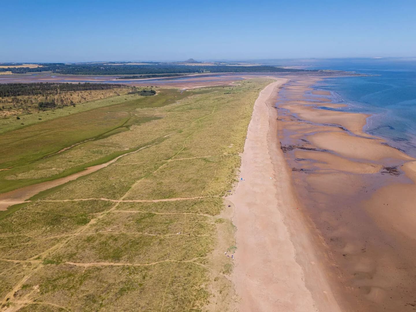 Aerial view of the wide sandy beach and dunes of Belhaven Bay