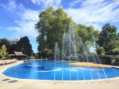 Children playing in the sprinklers at Stoke Park Paddling Pool, Guildford