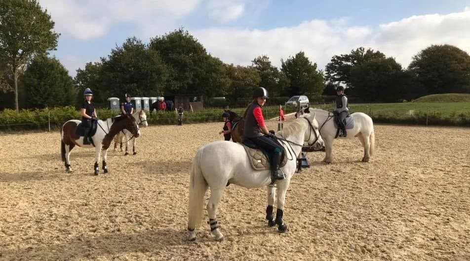 Children riding ponies in the arena during a Pony Day at Little Brook Equestrian