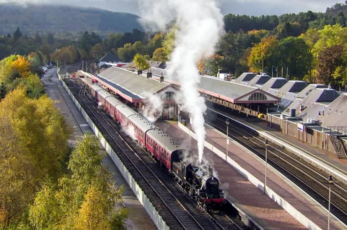 Steam locomotive 46512 with a train of carriages standing at Aviemore Station