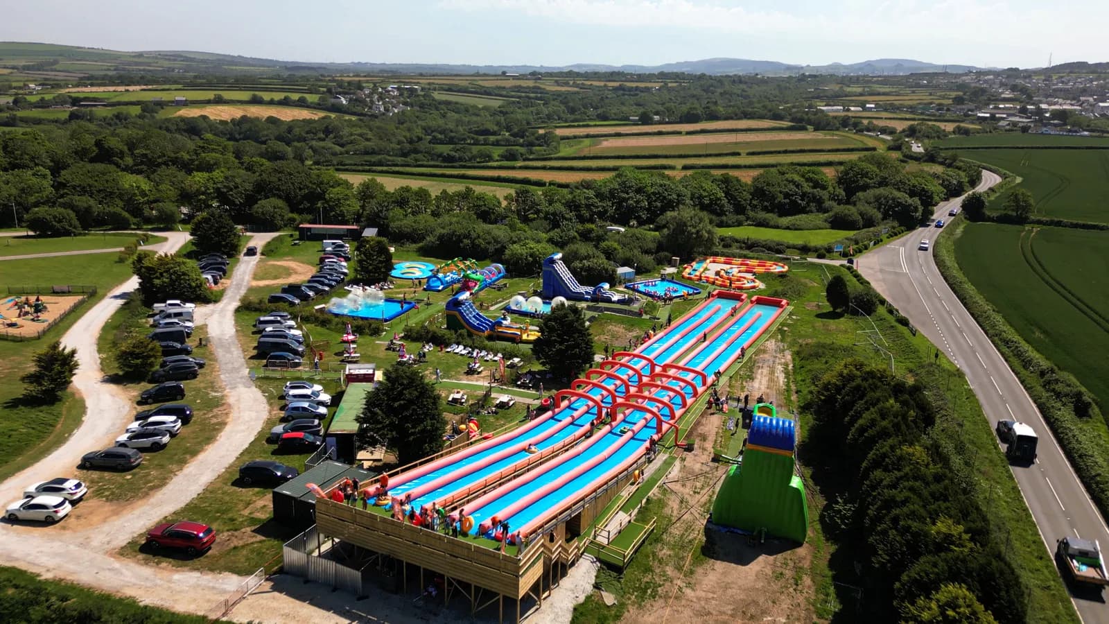 Aerial view of the giant 350ft multi-lane inflatable slip and slide at Cornwall Slip & Slide, Atlantic Reach near Newquay