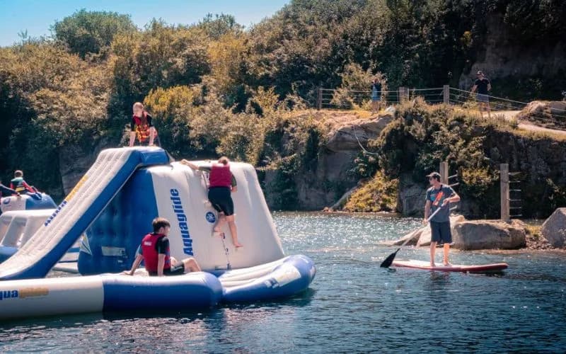 Children climbing and sliding on the inflatable Aquaglide aquapark at Kernow Adventure Park
