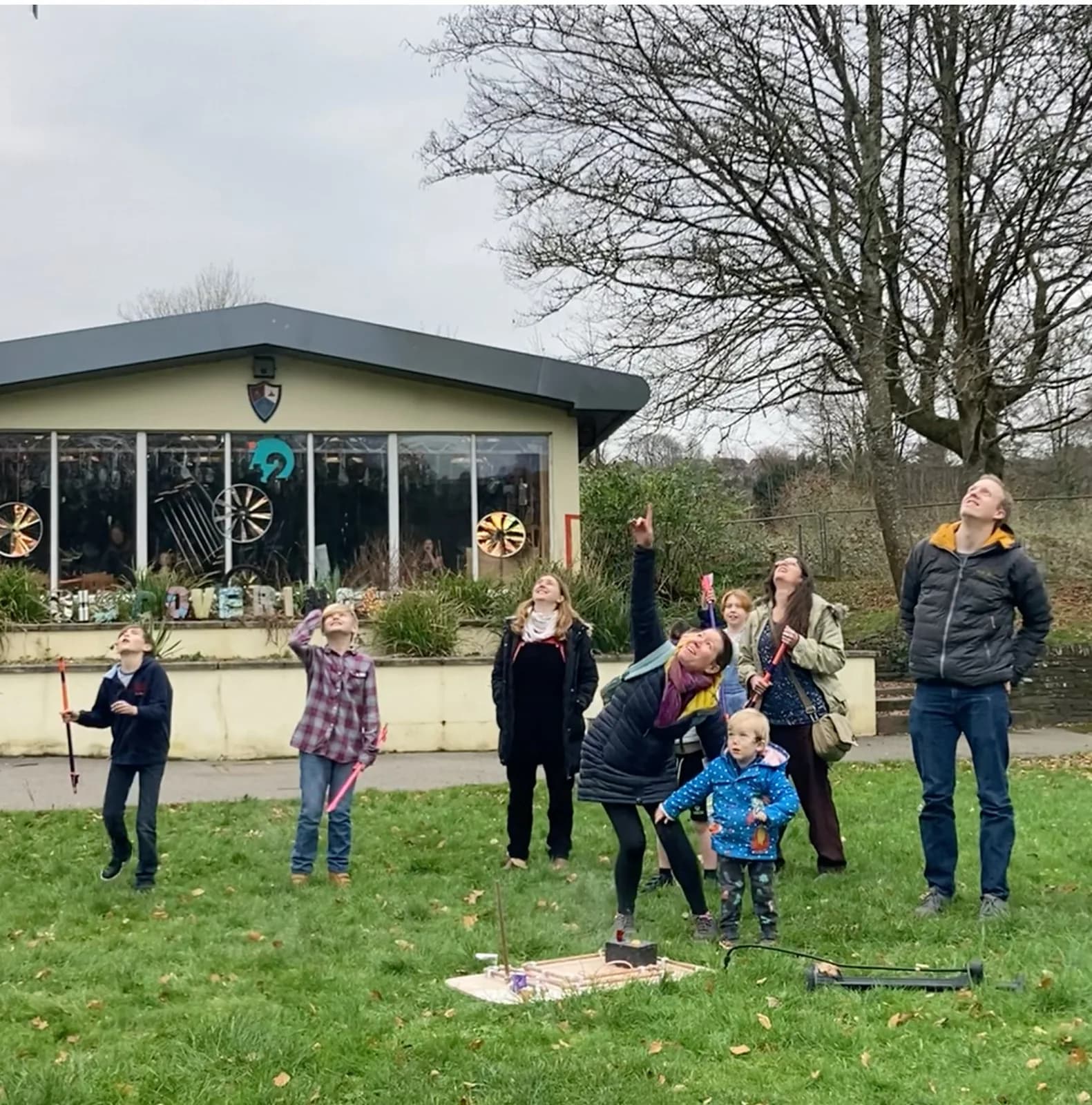 Families launching a homemade water rocket outside Discovering 42's brick museum building in Bodmin