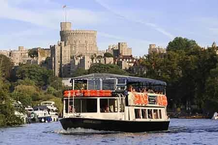 French Brothers passenger boat cruising the River Thames with Windsor Castle in the background