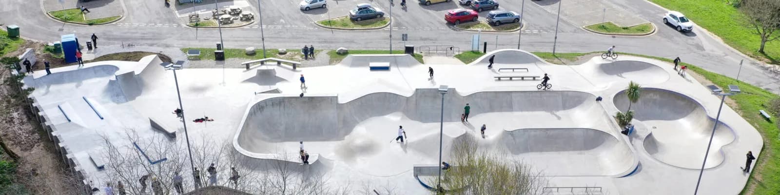 Aerial view of Newquay Skatepark's concrete bowls, ramps and street course, with the Trenance Leisure Park car park alongside