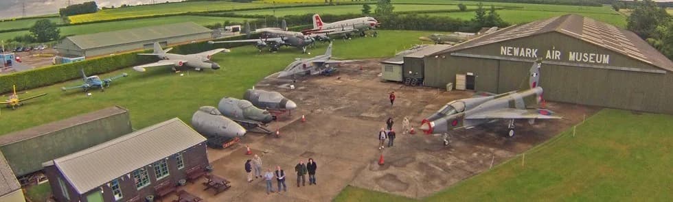 Aerial view of Newark Air Museum's outdoor aircraft collection with the main hangar