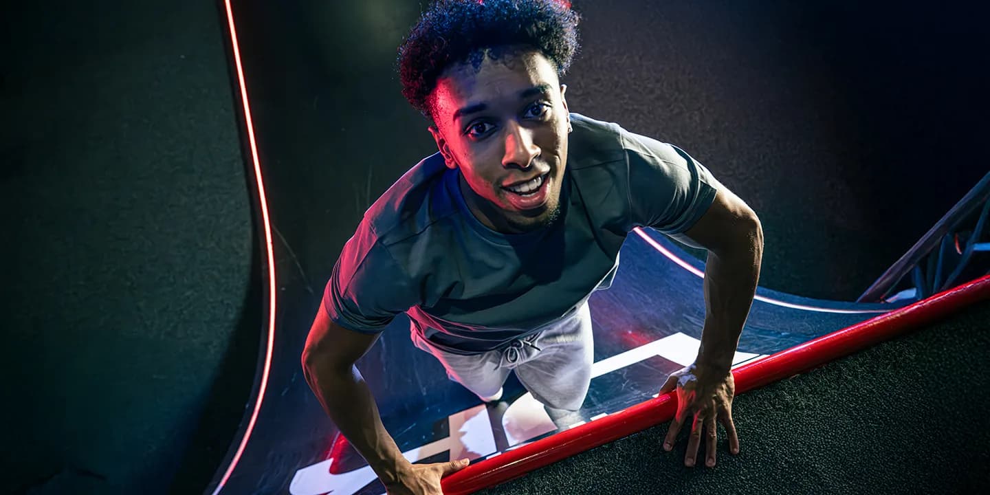 Adult tackling the ninja obstacle wall at Ninja Warrior UK Walsall