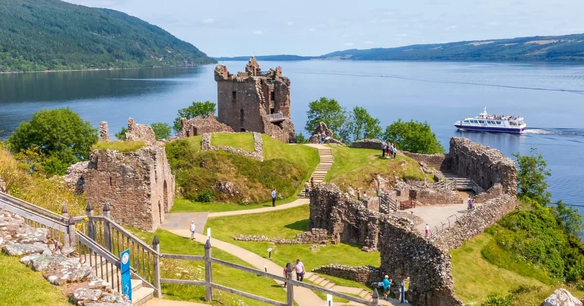 Urquhart Castle tower with a boat on Loch Ness